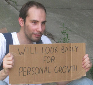 Josh holding a cardboard sign reading ‘Will look badly for personal growth’ during his 30-day fear challenge